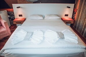 A neatly made bed with pillows, a wooden nightstand with a lamp, and a brick wall in the background. - Pablo Suit Hotel (Istanbul)