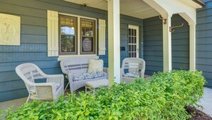 A porch with wicker furniture and a small garden area. - Walkable Thiensville Retreat Near Hiking! (Mequon)