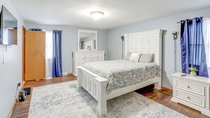 A bedroom with a white bed, a wooden wardrobe, a white dresser, and a blue and white patterned rug. - Lake Erie Family Getaway in Amherst: Pets Welcome! (Amherst)