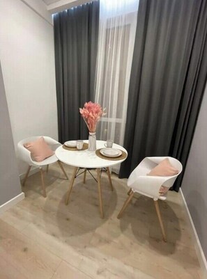 Cozy retreat with a round table, two chairs, and a vase with fresh flowers.