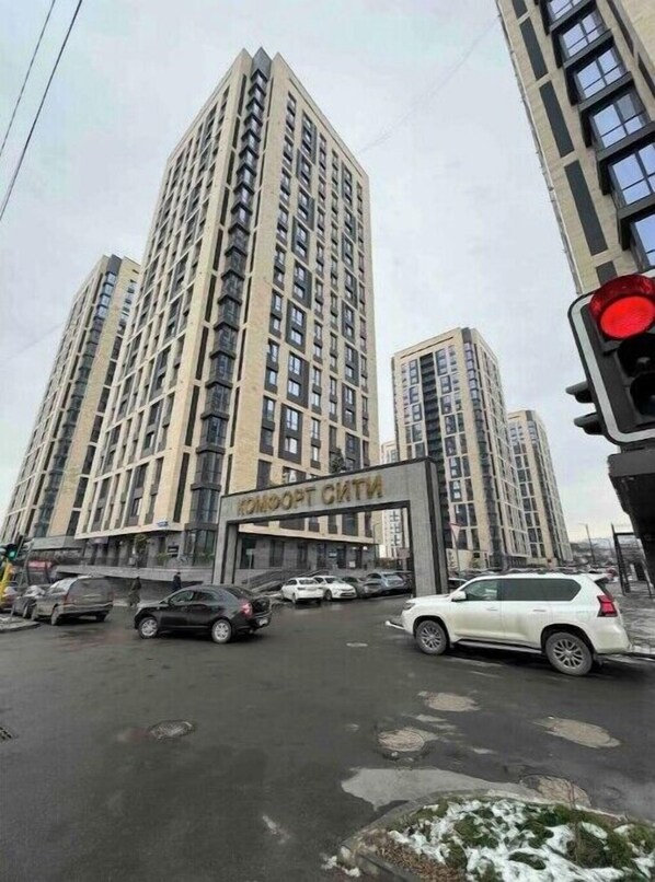 Stylish high-rise building with a grid-like facade and a prominent entrance.