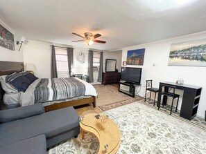 Relax in a well-appointed room with a comfortable sofa, flat-screen TV, and workspace.