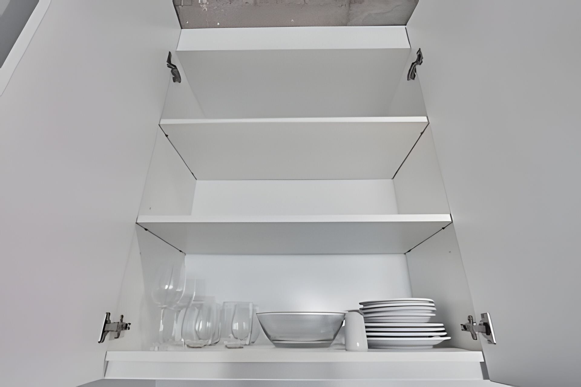 Un mueble blanco de varios niveles, con estantes y una superficie plana en la parte inferior.