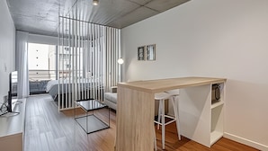 Een moderne, minimalistisch ingerichte slaapkamer met een bed, een bureau en een stoel.