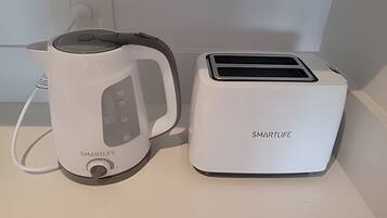 A kitchen with a kettle and a toaster.