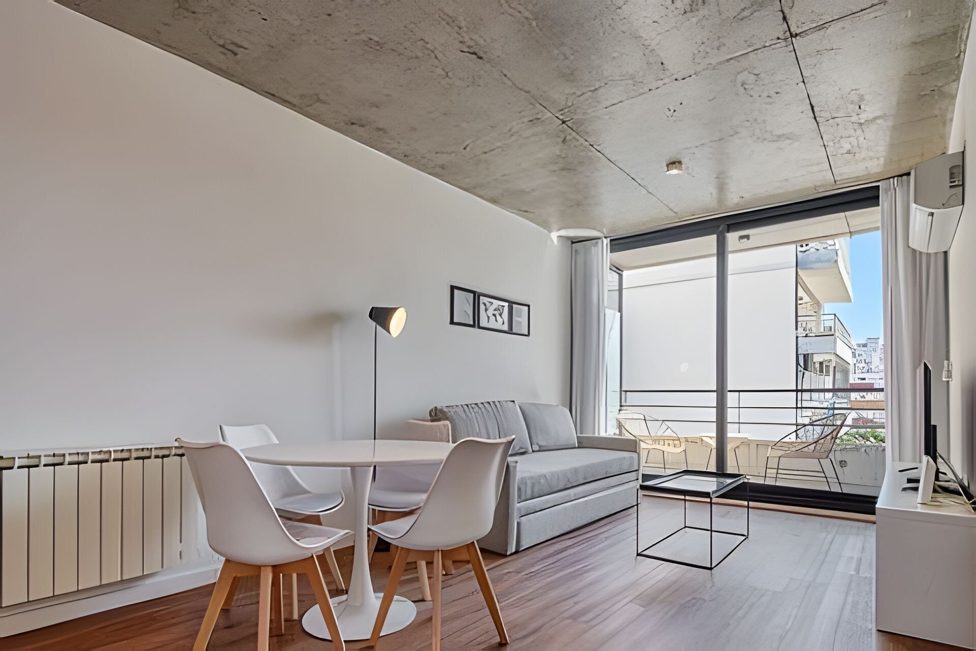 Uma sala de estar moderna com área de jantar, janelas amplas e vista para a cidade.