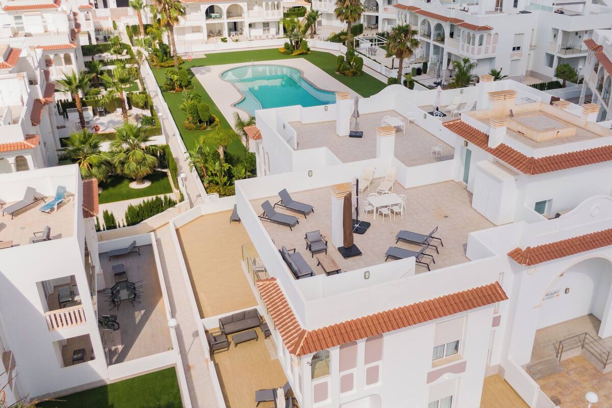 A resort with multiple buildings, a swimming pool, and outdoor seating areas.
