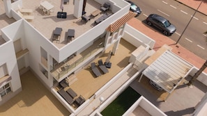 A multi-level outdoor area with seating, a pool, and a car parked nearby.