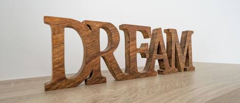 Wooden letters spelling "DREAM" on a wooden surface.