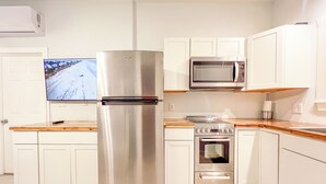 A modern kitchen with white cabinetry, a stainless steel refrigerator, a microwave, and an oven. - 5 minutes from the beach! Water access with kayaks and launch from house! (Swansboro)