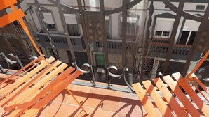Una terraza con barandillas de metal naranja y suelo de baldosas.