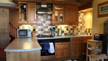 A kitchen with wooden cabinets, a microwave, a stove, and a dishwasher.