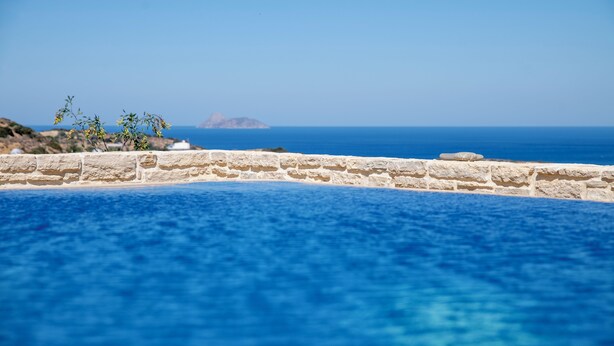 A stone wall with a clear view of the sea and a distant island. - Villa Kassandra (Pitsidia)