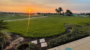 A golf course with a sunset view, palm trees, and a clear sky. - Reunion Charming Disney & Star Wars Themed Home (Kissimmee)