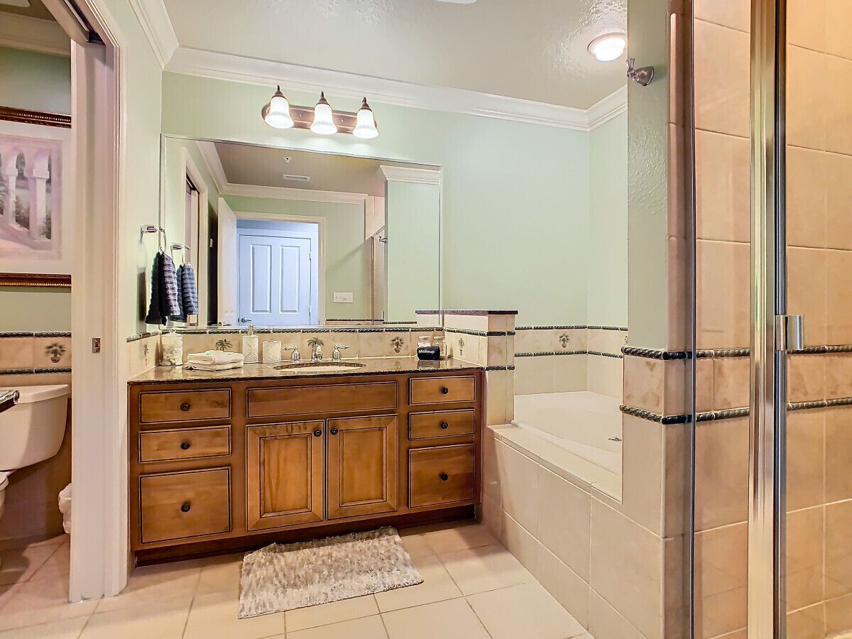 A bathroom with a wooden vanity, a bathtub, and a shower area.