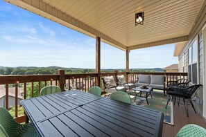 Relax on the patio with a view of the surrounding hills, surrounded by comfortable seating and a stylish table setting.