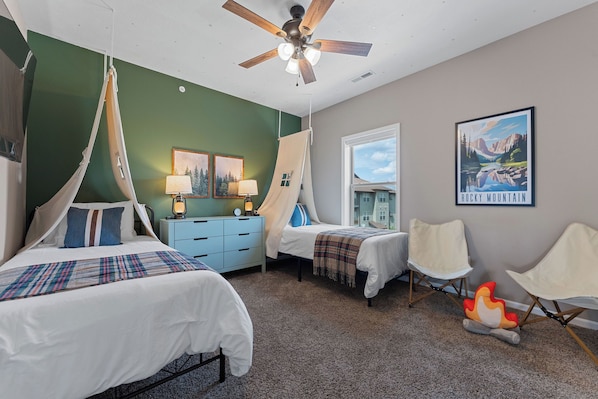 Cozy retreat with a large bed, two additional beds, and a seating area.