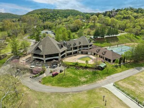 Stunning building with a unique architectural style, surrounded by lush greenery and rolling hills.
