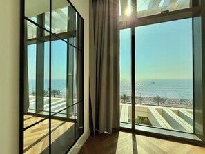 A room with large floor-to-ceiling windows offering a view of the sea and a beach. - The8, 1-bed Luxury Residence in Palm Jumeirah (Dubai)