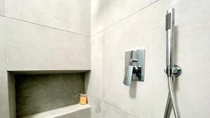 A modern bathroom with a built-in shelf, a showerhead, and a towel rack. - Elegante Appartamento Vista sul Duomo di Firenze  (Firenze)