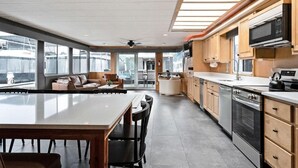 Une cuisine moderne dotée d’un îlot central, de meubles en bois et d’une grande fenêtre donnant sur une marina.