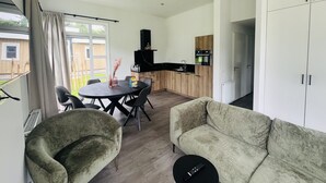 A modern living space with a dining area, two sofas, a kitchen, and a large wardrobe.