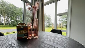 A table with a wooden surface, two clear glass vases with dried flowers, and a cardboard box with text.