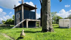 Une structure en bois avec une rampe et un arbre à proximité.