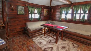 A cozy log cabin interior with a wooden bench, a sofa, and a table.
