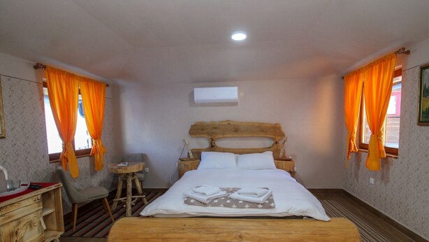 A bedroom with a wooden bed, a desk, a chair, and a small table. - Ethno Village Dolina Mira - One Bedroom Holiday Home (Drina) (Pale)