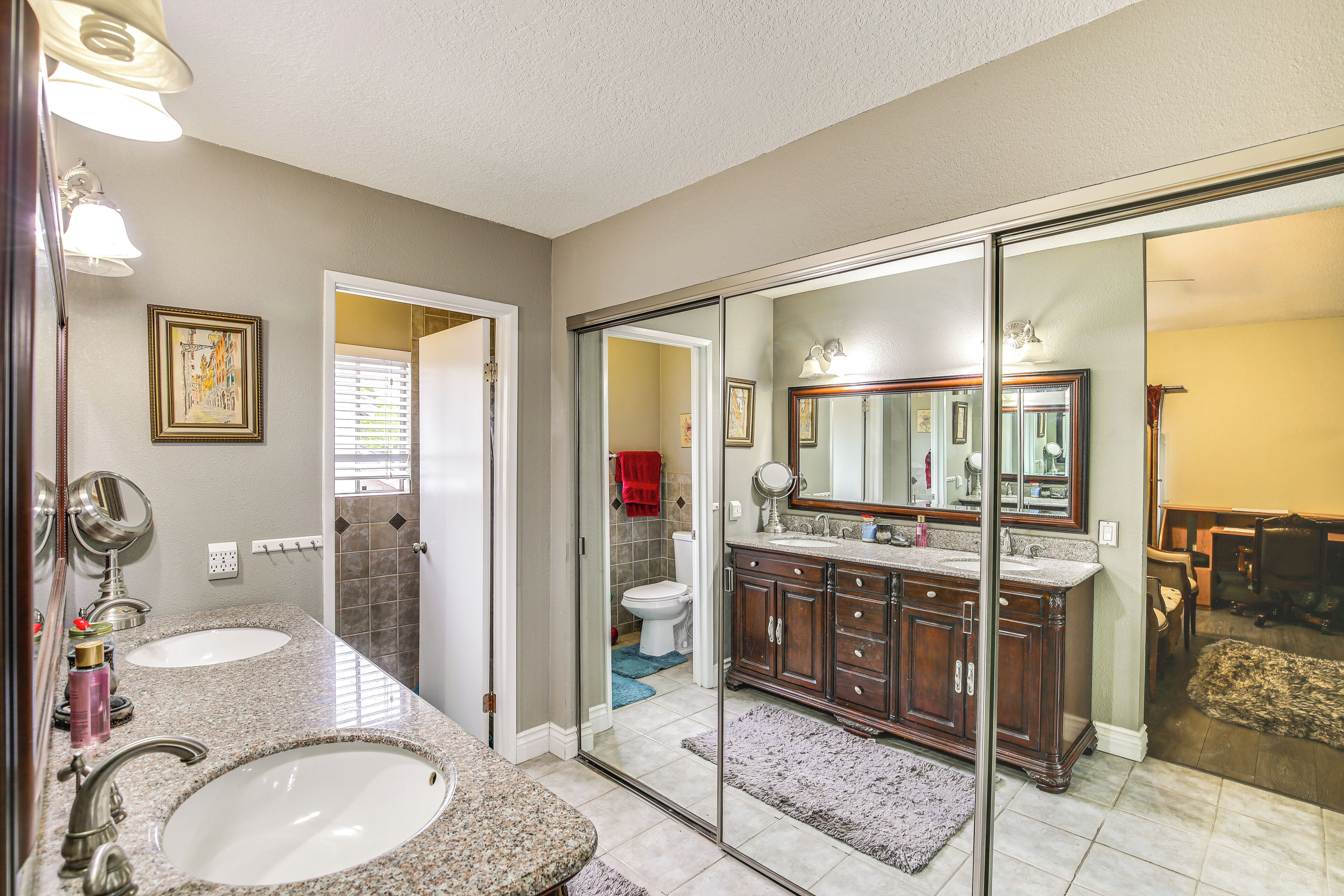 A bathroom with two sinks, a large mirror, and a glass shower door.