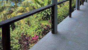 A covered balcony with a view of the ocean and tropical vegetation. - Family Friendly, centrally located - modern & spacious 2 bed 2 bath retreat.  (Tortola)
