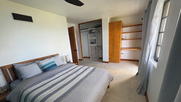 A bedroom with a bed, a ceiling fan, a wardrobe, and a walk-in closet. - Family Friendly, centrally located - modern & spacious 2 bed 2 bath retreat.  (Tortola)