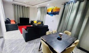 Relax in this stylish living area with a flat-screen TV, comfortable sofa, and dining table for four.