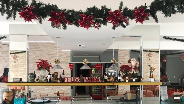 Een restaurant met een geel aanrecht, kerstversiering en een grote spiegel die het interieur weerspiegelt.