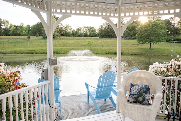 A gazebo with a pond, chairs, and a view of the landscape. - Charming 3 bedroom farmhouse retreat. Peaceful, scenic, and full of adventure. (Ellenboro)
