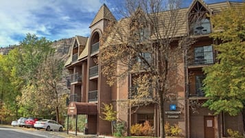 Un immeuble à plusieurs étages avec une façade en briques, une enseigne indiquant « Wyndham Durango » et un parking avec des voitures.