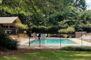 A swimming pool surrounded by a fence, with a covered area and trees in the background. - Walk to Sanford Stadium/DT w/view Dawg Friendly! (Athens)