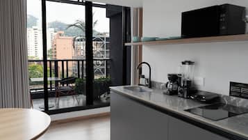 Suite estudio Premier, vista a la ciudad | Caja de seguridad en la habitación y espacio para trabajar con laptop