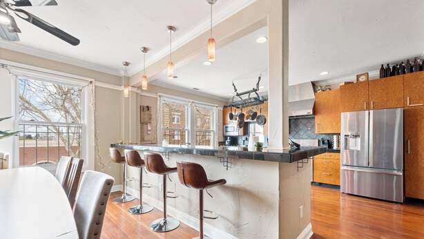 A modern kitchen with a central island, stainless steel appliances, and wooden flooring. - Downtown loft in the heart of Lodi. Great for large groups! (Lodi)