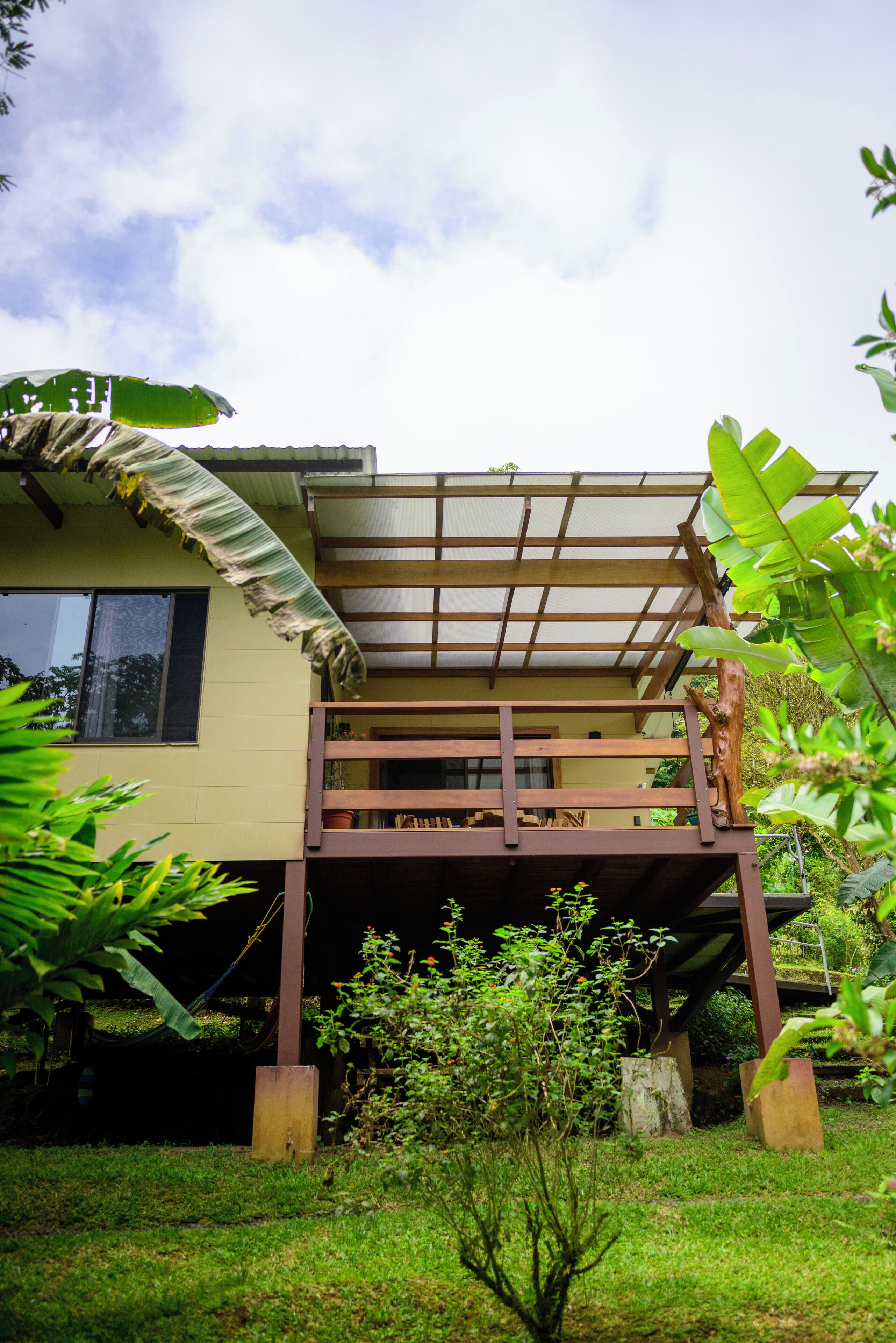 A two-story house with a wooden balcony and a thatched roof.