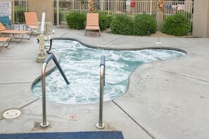 A hot tub with a 'No Diving' sign, surrounded by lounge chairs and a fence. - Indio | Mobility-Friendly Resort Stay | Desert Sun & Pools | Accessible Studio (Indio)