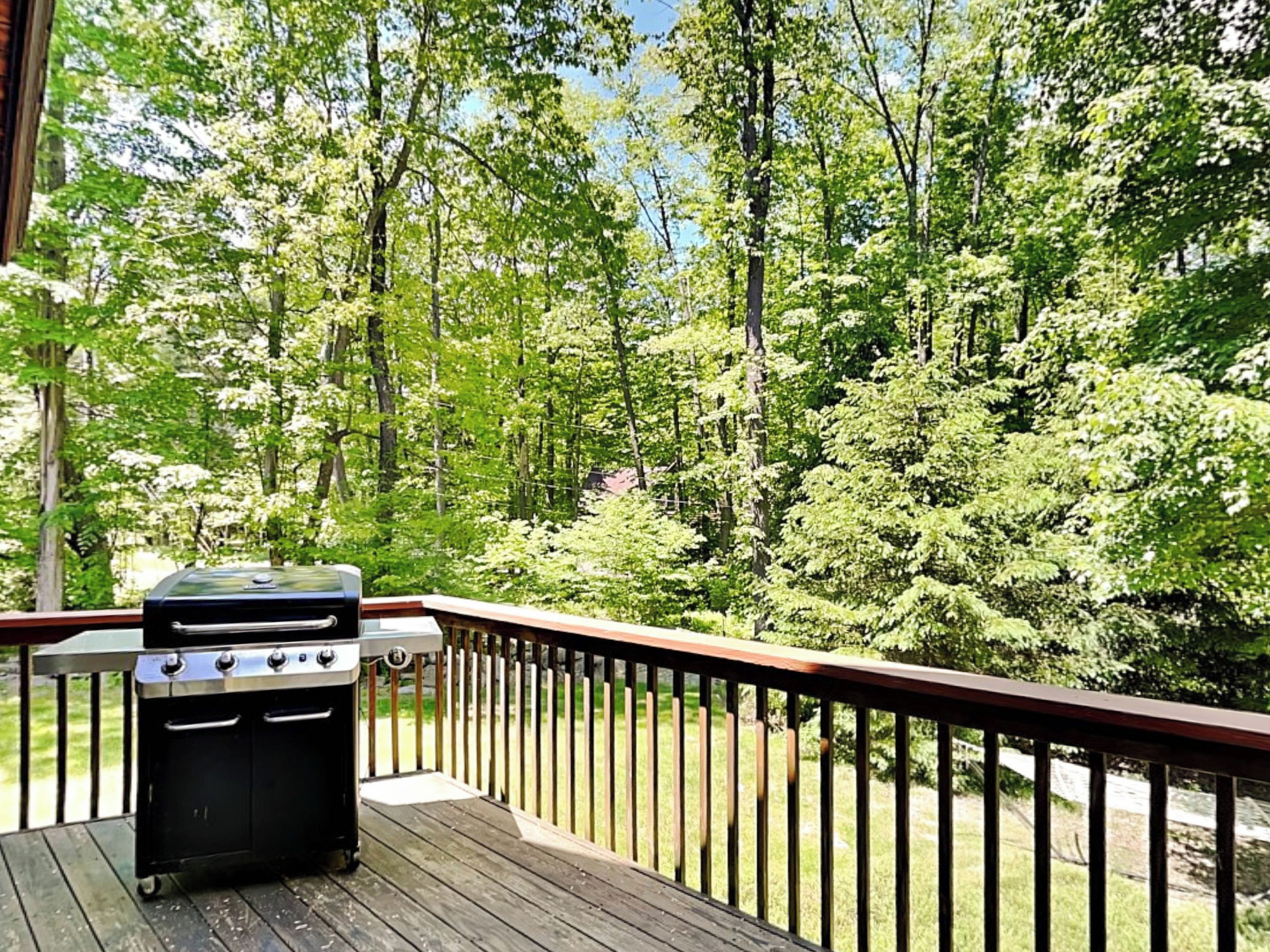 Une terrasse en bois avec un barbecue.