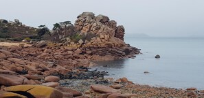 A rocky coastline with large boulders and a calm sea. - Ty Denise House (Rospez)