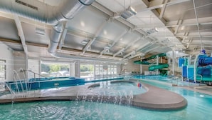 Piscina interna com hidromassagem, toboáguas e área de recreação aquática.