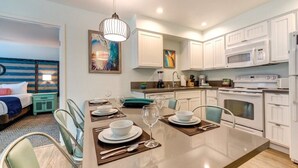 A modern kitchen with white cabinets, a dining table set for four, and a large island. - WorldMark Mission Valley - 2 Bedroom Twin (San Diego)