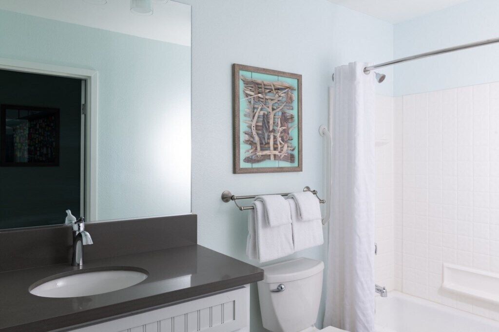 A bathroom with a sink, toilet, and shower curtain.
