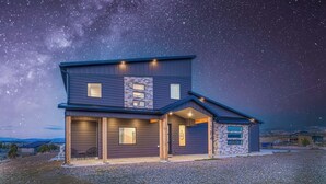 A two-story house with a garage, a covered porch, and a starry night sky. - The Meadow at Natl Parks -Hot Tub- Sleeps 10-Family (Hatch)