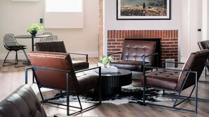 Un salon moderne avec des canapés en cuir, une table basse et une cheminée.