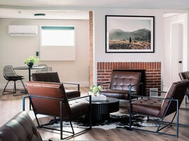 Una sala de estar moderna con sofás de cuero, una mesa de centro y una chimenea.